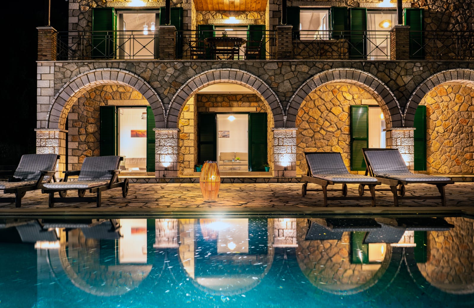 Illuminated stone arches above the pool at night